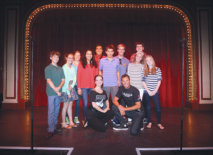 Image of a group of our FastForwad reporters posing on stage with two Beach Blanket Babylon cast members