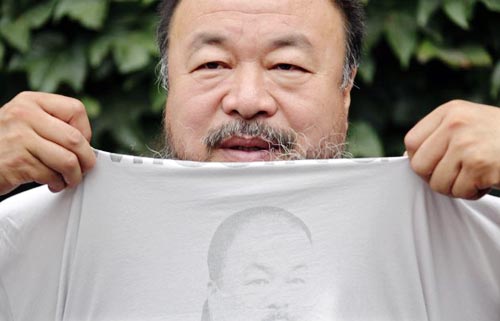Image of Chinese dissident artist Ai Weiwei pulling up his shirt bearing a portrait of himself as he chats with journalists at the courtyard of his studio before his verdict hearing in Beijing, July 20, 2012.