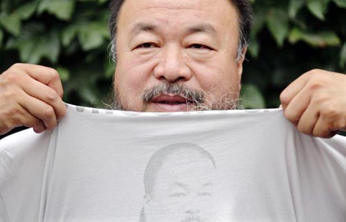 Chinese dissident artist Ai Weiwei pulls up his shirt bearing a portrait of himself as he chats with journalists at the courtyard of his studio before his verdict hearing in Beijing, July 20, 2012. Image of Chinese dissident artist Ai Weiwei pulling up his shirt bearing a portrait of himself as he chats with journalists at the courtyard of his studio before his verdict hearing in Beijing, July 20, 2012.